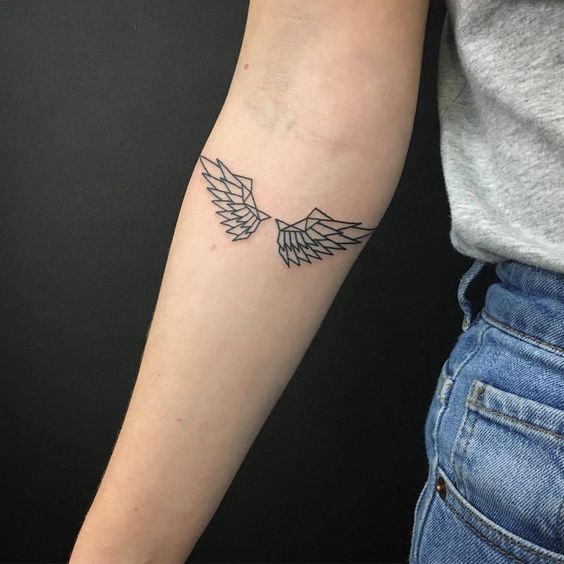 Minimalistyczny tatuaż skrzydła na przedramieniu